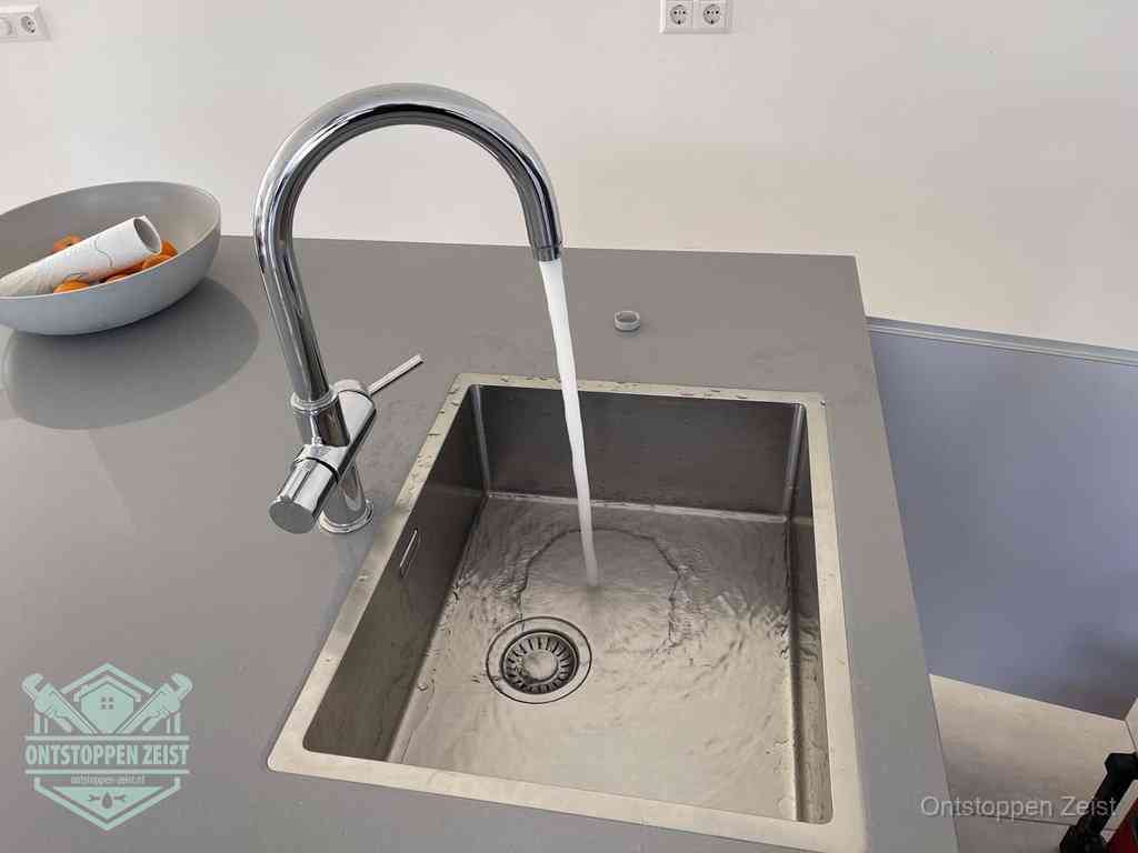 Een vrij doorstromende rvs spoelbak waar het water moeiteloos wegloopt, het resultaat van slim onderhoud dat geld bespaart in Zeist Een vrij doorstromende rvs spoelbak waar het water moeiteloos wegloopt, het resultaat van slim onderhoud dat geld bespaart in Zeist