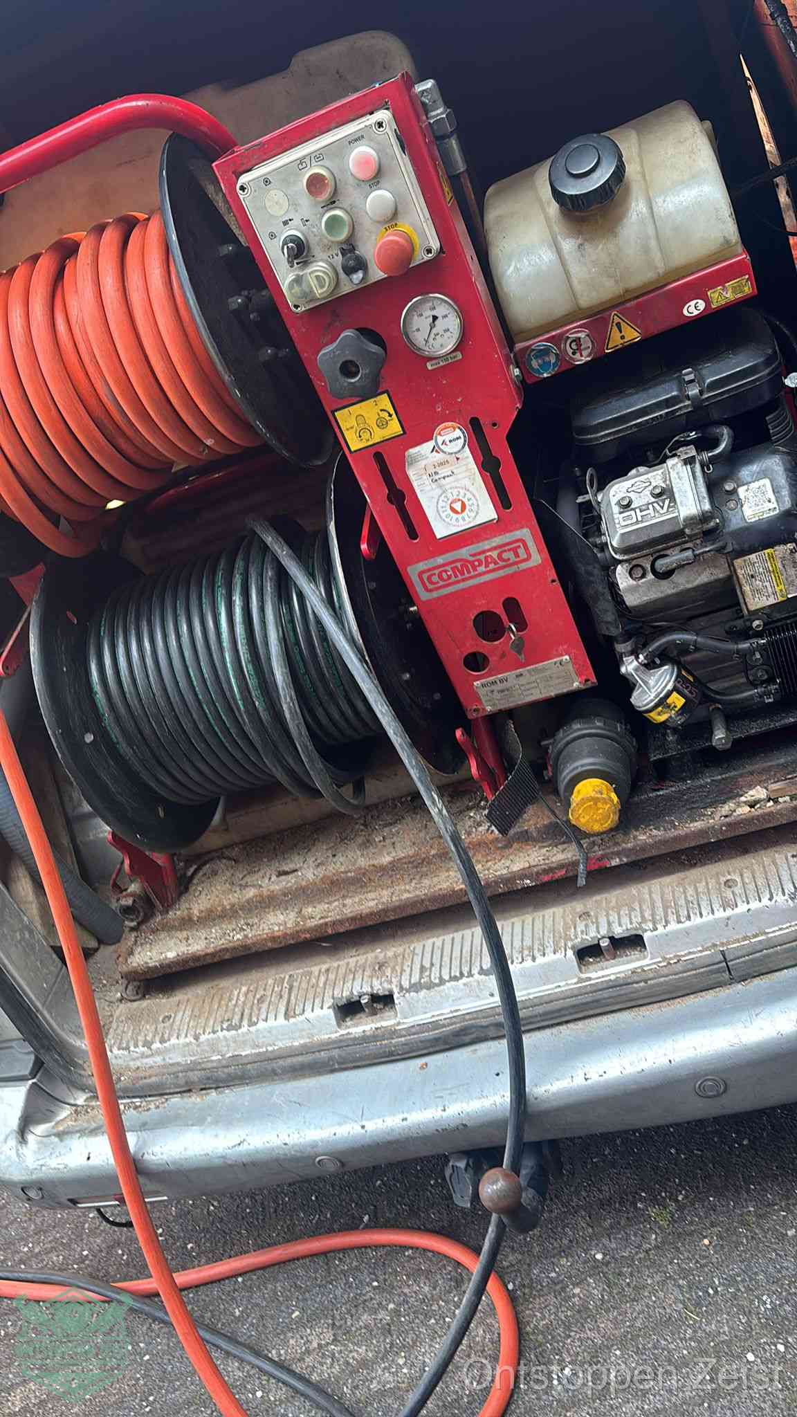 Een rood hogedruk-rioolreinigingstoestel in de laadbak van de bedrijfsbus, apparatuur voor een hardnekkige afvoerverstopping in Zeist