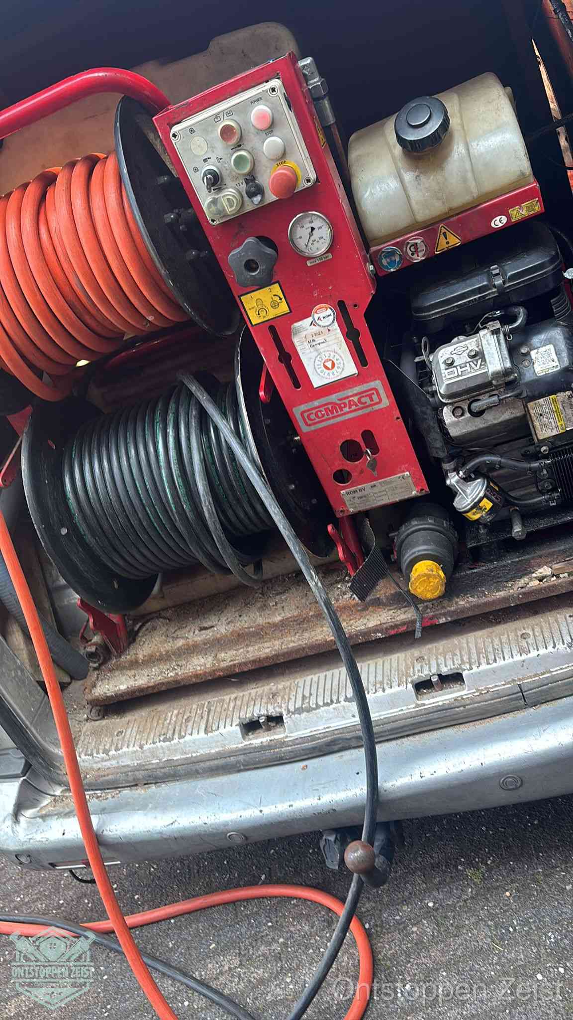 Een rood hogedruk-rioolreinigingstoestel met slangen in de laadbak van de bedrijfsbus, apparatuur voor een hardnekkige wc-verstopping in Zeist Een rood hogedruk-rioolreinigingstoestel met slangen in de laadbak van de bedrijfsbus, apparatuur voor een hardnekkige wc-verstopping in Zeist